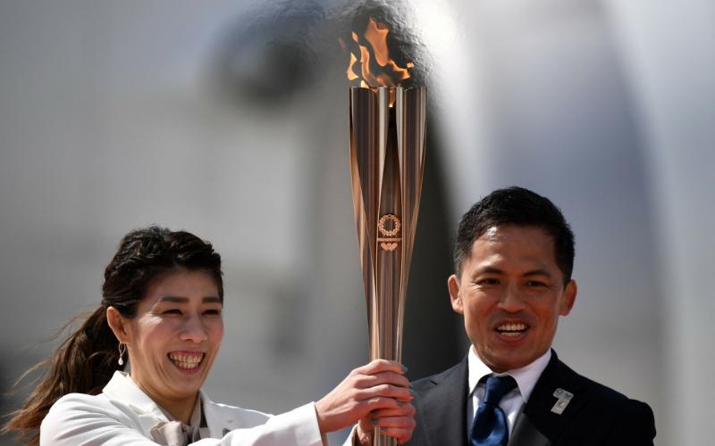 Los japoneses medallistas de oro olímpicos Saori Yoshida y Tadahiro Nomura sosteniendo la antorcha olímpica de Tokio 2020, después de transportar la llama desde Grecia, en la Fuerza de Autodefensa Aérea de Japón.
